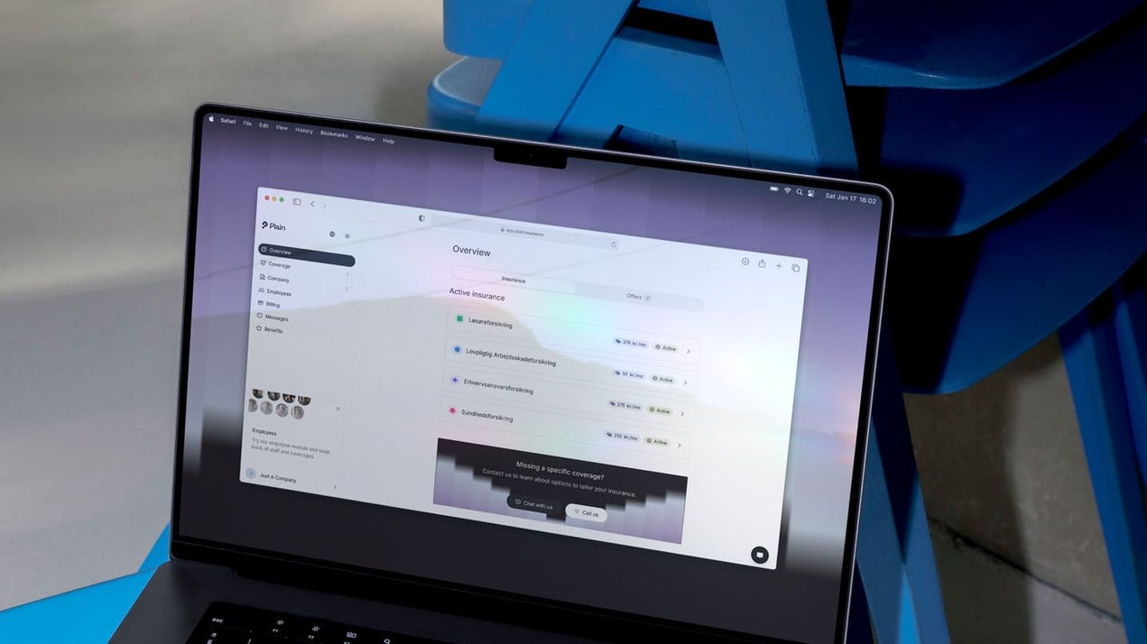 Laptop showing a digital insurance dashboard with active business insurances, Arbejdsskadeforsikring and payment overview for small businesses.